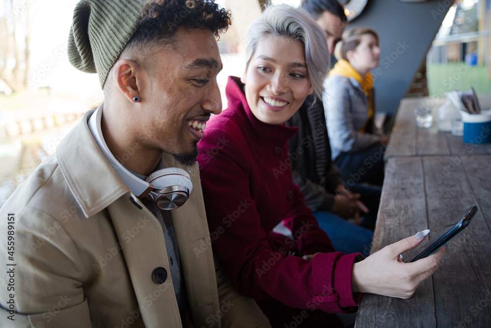 Smiling young couple taking selfie with camera phone Smiling young couple taking selfie with camera phone