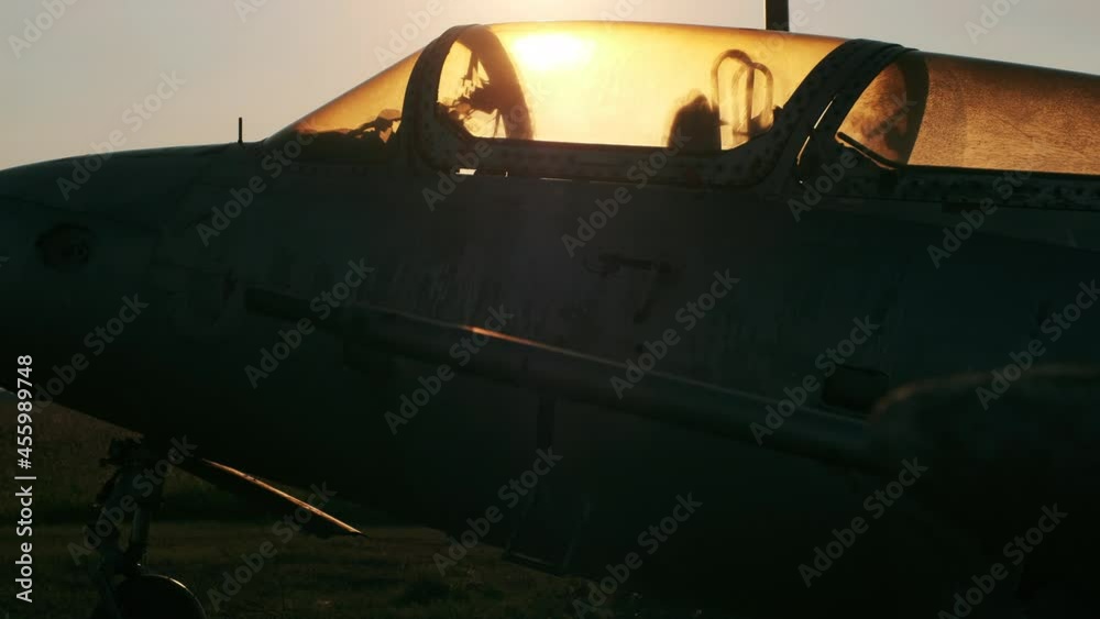 Dark silhouette of old broken Delfin L-29 training aircraft standing at abandoned military air base at sunset close side view