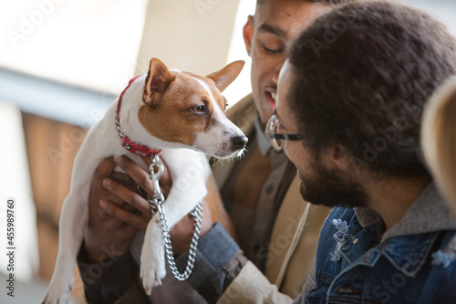 Canvas Print Man holding dog, talking to friend outdoors
