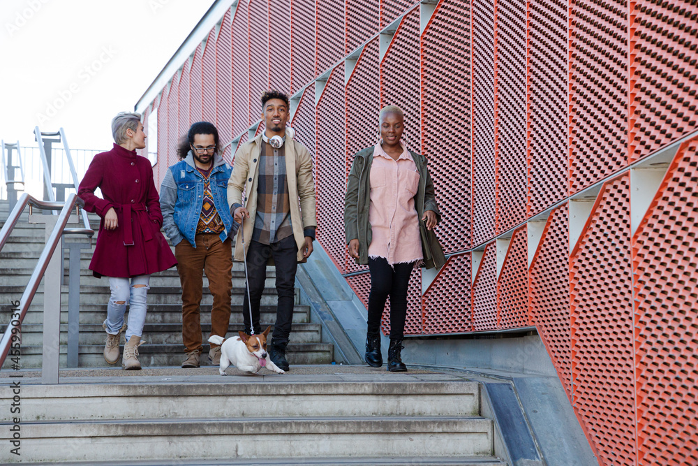 Obraz premium Young friends walking down down urban, modern stairs