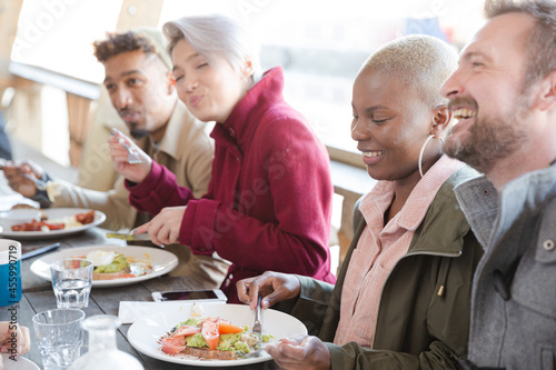 Portrait of smiling friends eating at restaurant outdoor patio