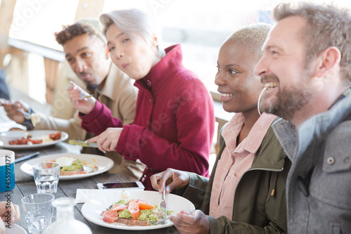 Portrait of smiling friends eating at restaurant outdoor patio