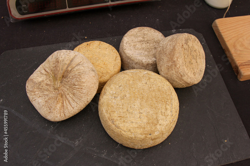 Slate board full of cheeses ready to be cut