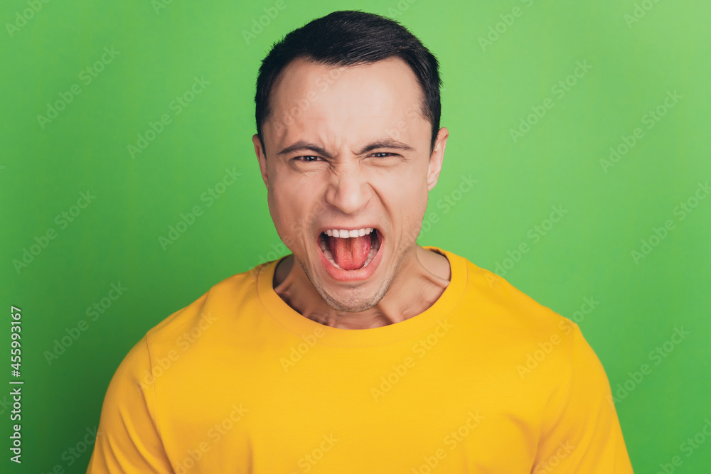 Portrait of angry aggressive guy scream open mouth on green background Portrait of angry aggressive guy scream open mouth on green background