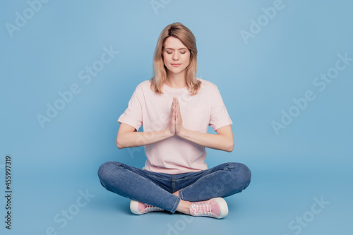 Portrait of charming fit lovely lady sit floor yoga practice concept on blue background