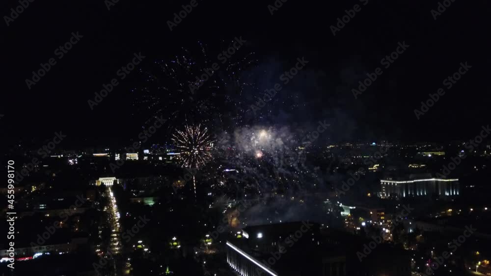 Night fireworks in the city. Flashes of lights and fireworks over the Park and houses. Visible streets, happy people. Festive mood. New year or Christmas. Night city lights, streets in the lanterns. Night fireworks in the city. Flashes of lights and fireworks over the Park and houses. Visible streets, happy people. Festive mood. New year or Christmas. Night city lights, streets in the lanterns.