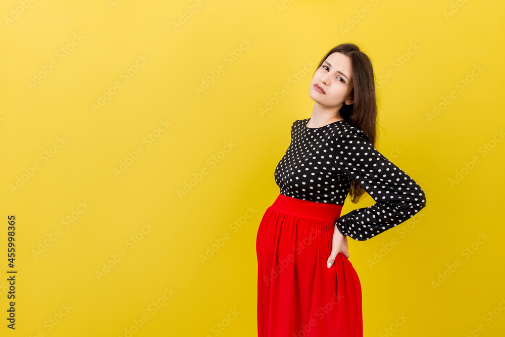 Pregnant woman with a pain in her back on colored Background isolated