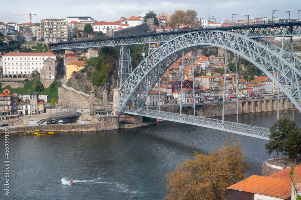 Fototapeta premium Porto, Portugal, October 31,2020. View on bridge, colorful old houses on hill in old part of city and embankment of Douro river in rainy day