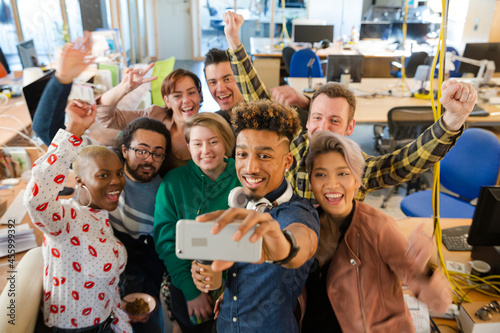 Team talking group selfie with smartphone in office