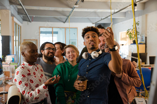 Team taking group selfie with smartphone in office © KOTO