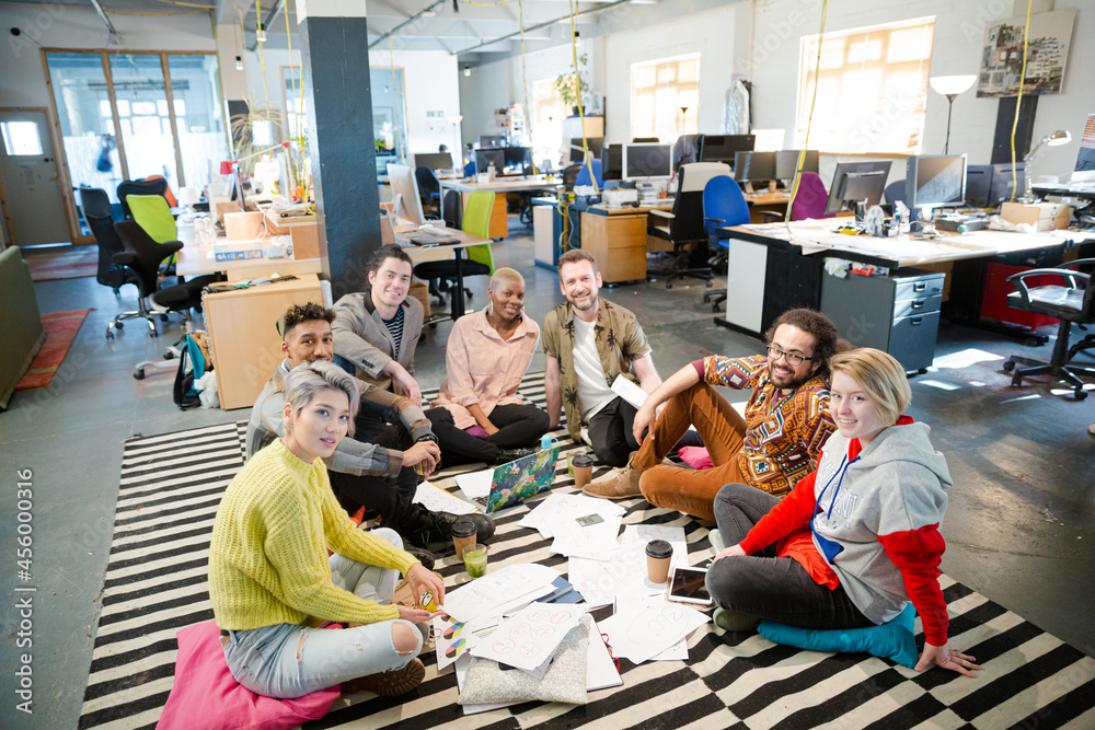 Team sitting on floor, discussing paperwork Team sitting on floor, discussing paperwork