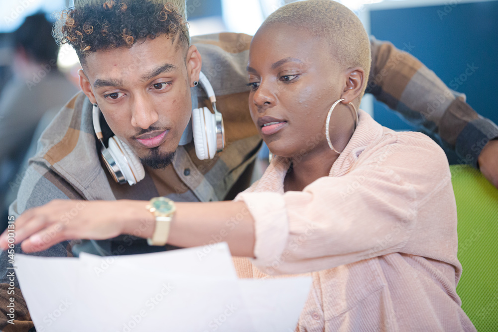 Fototapeta premium Man and woman discussing paperwork at computer