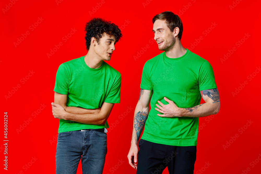 two friends green t-shirts communication lifestyle red background
