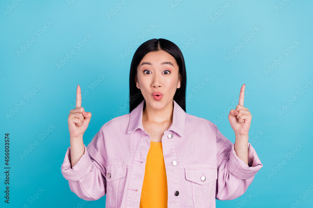 Portrait of attractive amazed cheerful girl pointing up copy space ad pout lips isolated over bright blue color background Portrait of attractive amazed cheerful girl pointing up copy space ad pout lips isolated over bright blue color background