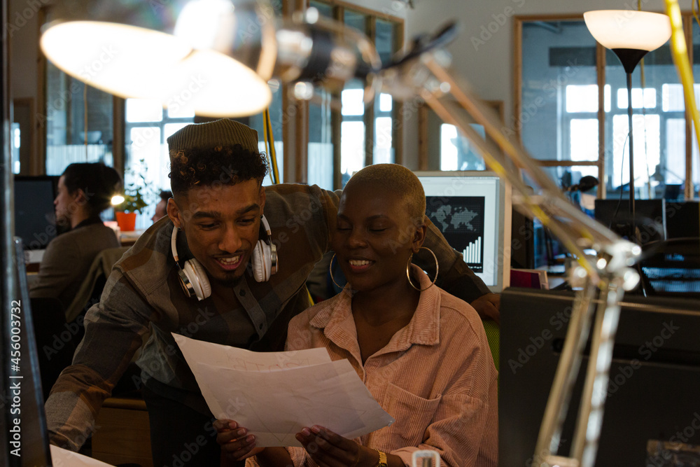 Fototapeta premium Man and woman discussing paperwork at computer