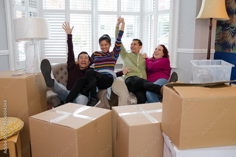 Friends taking a break from moving, relaxing in living room Friends taking a break from moving, relaxing in living room