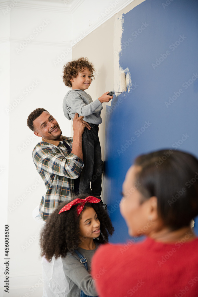 Happy family painting wall