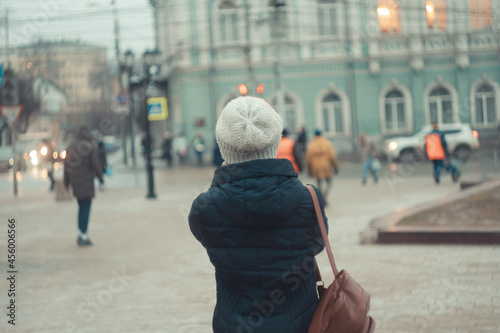 a girl in a winter hat walks around the city