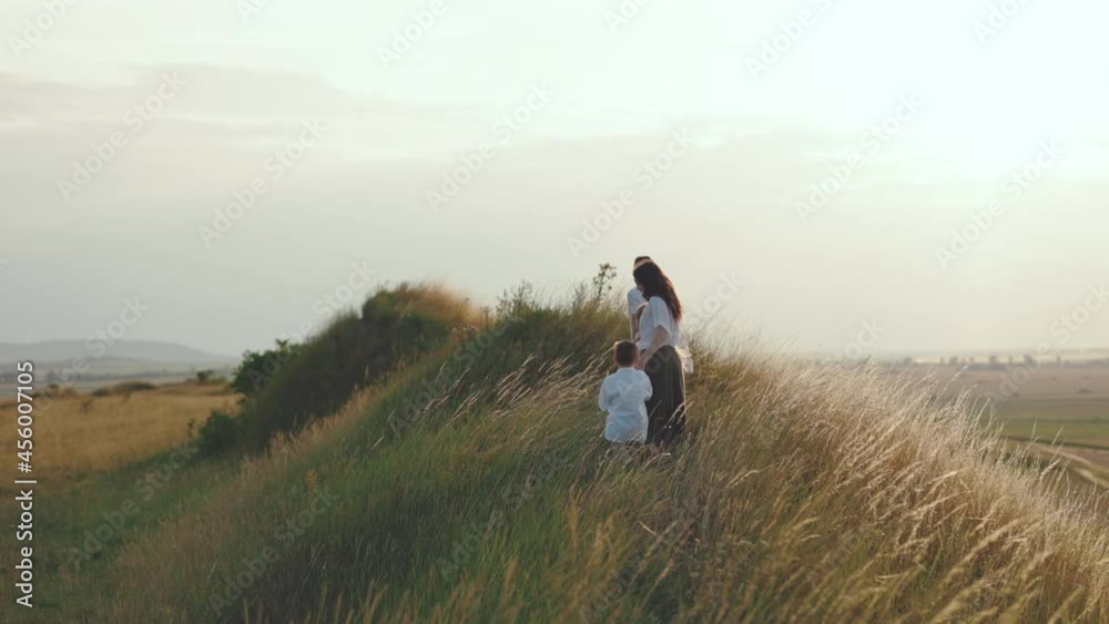 Caucasian family of four keeping hands while walking on hill Caucasian family of four keeping hands while walking on hill