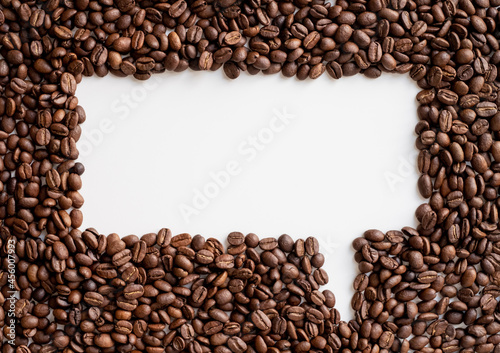 Group of roasted grains of black coffee beans forming a message icon shape on white background. Free space for your text