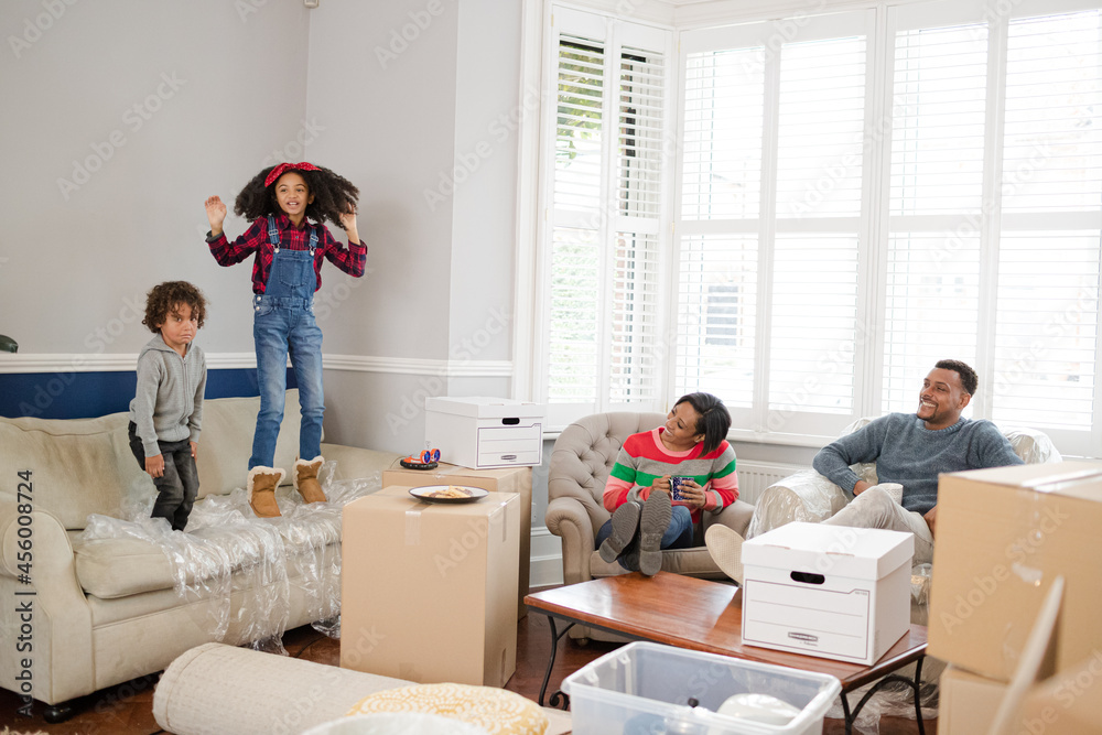 Obraz premium Family taking a break from moving, relaxing in living room