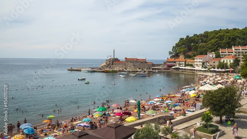 Relaxation on beach, seaside resort with people and boats moving time lapse video. Petrovac Montenegro. photo
