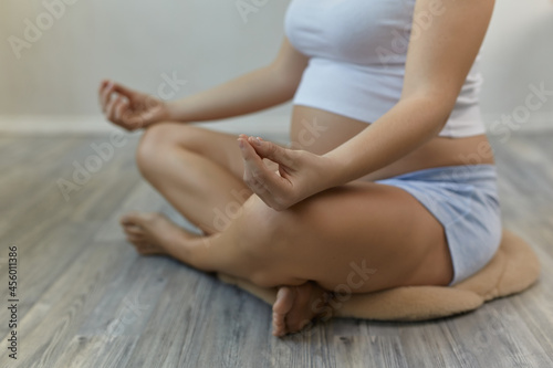 Close-up view of young pregnant woman doing morning yoga exercise