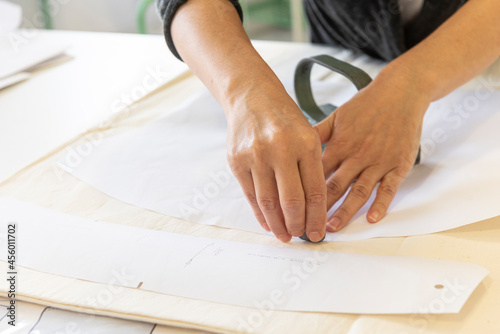 A woman draws and cuts a clothing pattern © Albert