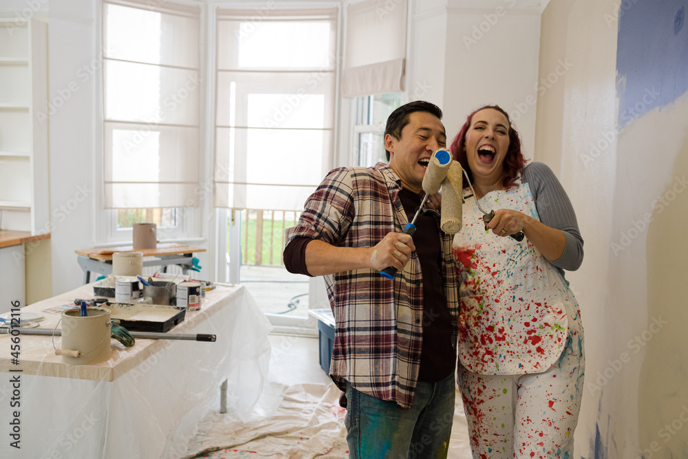 custom made wallpaper toronto digitalHappy, playful couple with paint rollers painting room