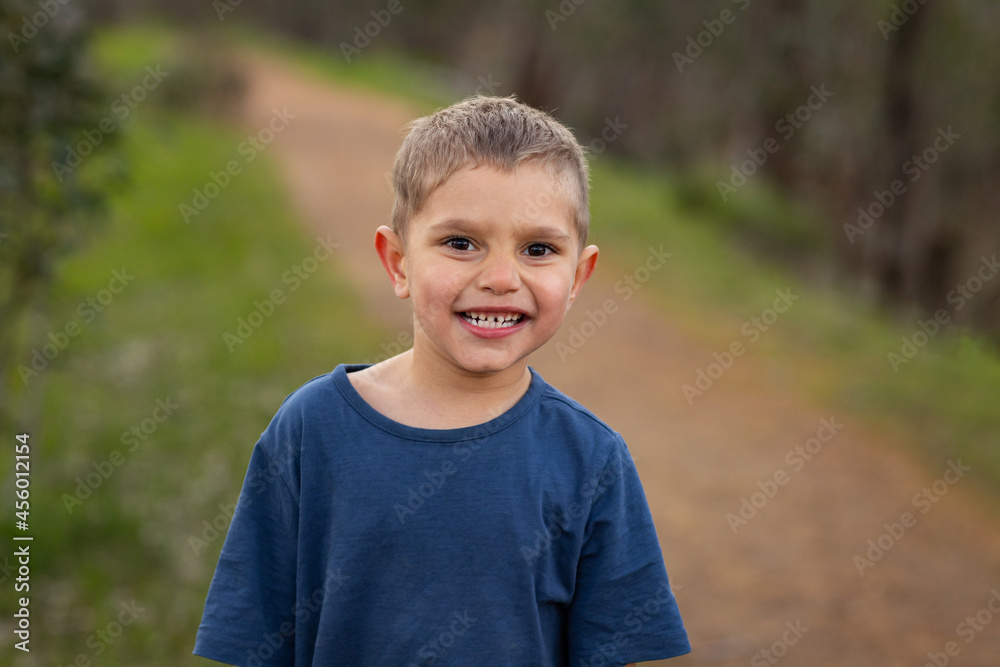 young kid outdoors smiling and looking at camera young kid outdoors smiling and looking at camera