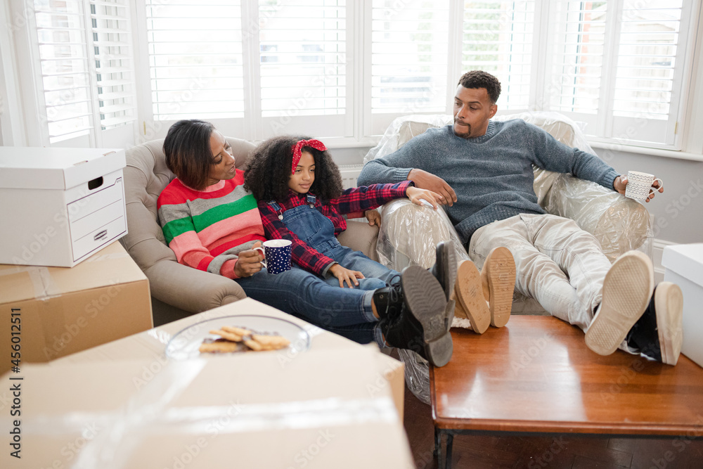 Fototapeta premium Family taking a break from moving, relaxing in living room