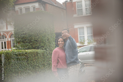 Happy couple taking a break from moving, looking at old house photo