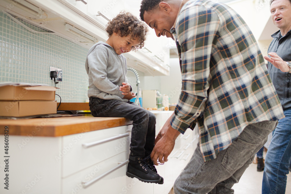 Fototapeta premium Father putting shoes on son
