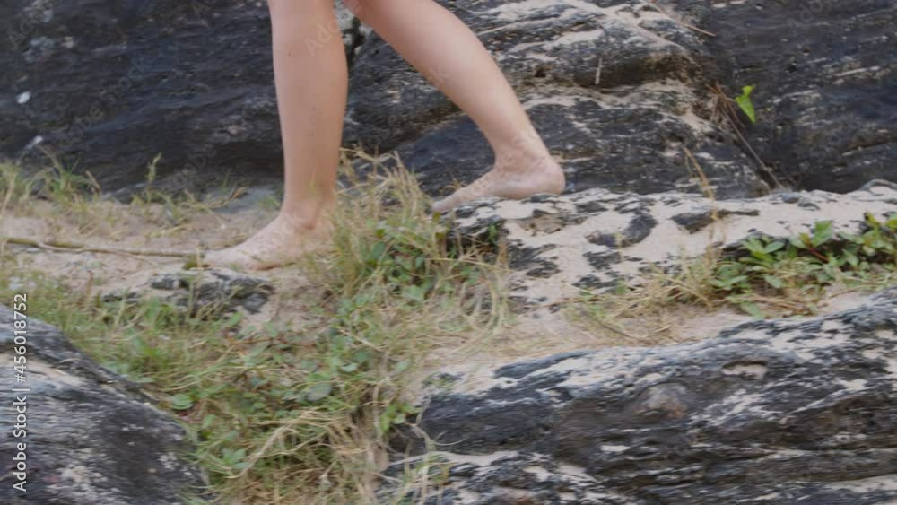 Brazilian girl walking barefoot at rocky beach, Balneário Camboriú, Brazil. Brazilian girl walking barefoot at rocky beach, Balneário Camboriú, Brazil.