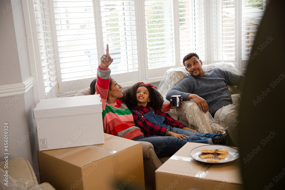 Family taking a break from moving, relaxing in living room Family taking a break from moving, relaxing in living room