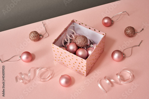 A box with Christmas or New Year ornaments on pink background