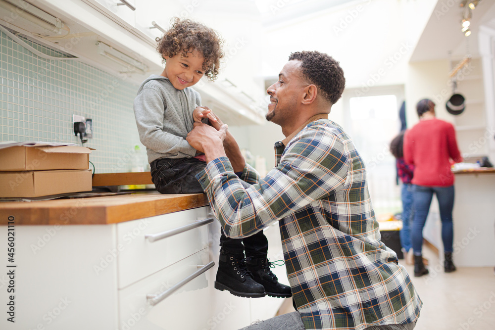 Obraz premium Father putting shoes on son