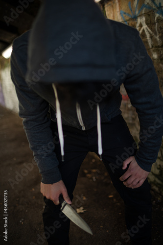 Dangerous man in hoody holding knife weapon in urban tunnel © KOTO