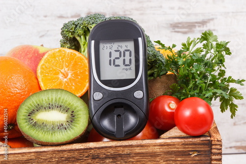 Glucometer for measuring sugar level with fruits and vegetables. Concept of diabetes, healthy lifestyles and nutrition