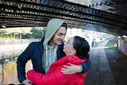 Happy  affectionate young couple hugging under urban bridge