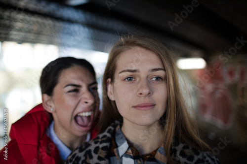 Angry young woman yelling at friend