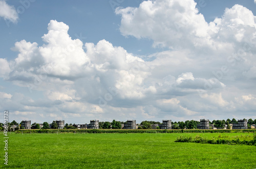 Zwolle, The Netherlands, August 4, 2021: seven towerlike residential buildings in a southern suburb at the edge of a green field under a sky with impressive clouds