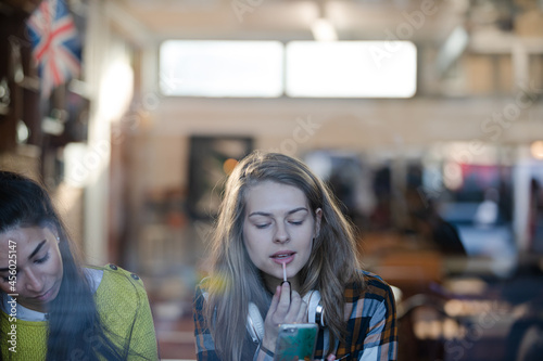 Young female college students studying at cafe window