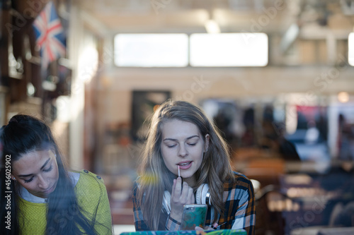 Young female college students studying at cafe window