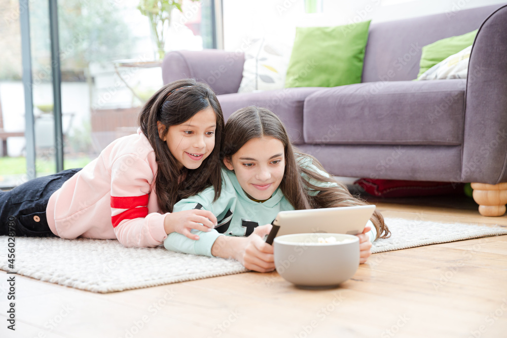 Girls taking selfie with digital tablet on living room floor Girls taking selfie with digital tablet on living room floor