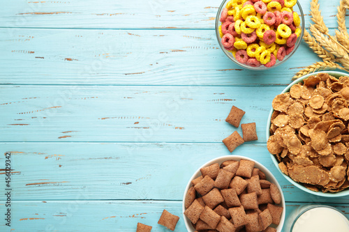 Foto Variety of cereals in blue bowls, quick breakfast on blue wooden background