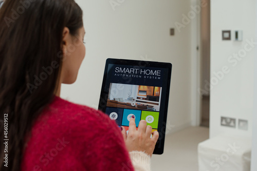 Woman using smart home automation system with digital tablet