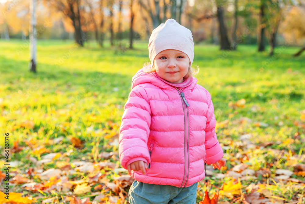 Happy young girl smiling in beautiful autumn park on nature walks outdoors. Little child playing in autumn fall orange yellow background. Hello autumn concept. Happy young girl smiling in beautiful autumn park on nature walks outdoors. Little child playing in autumn fall orange yellow background. Hello autumn concept.