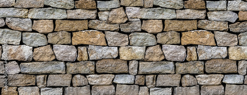 stone wall made of old and weathered cobblestones wall of an old house