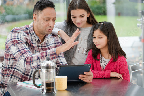 Wallpaper Mural Father and daughters using digital tablet in morning kitchen Torontodigital.ca